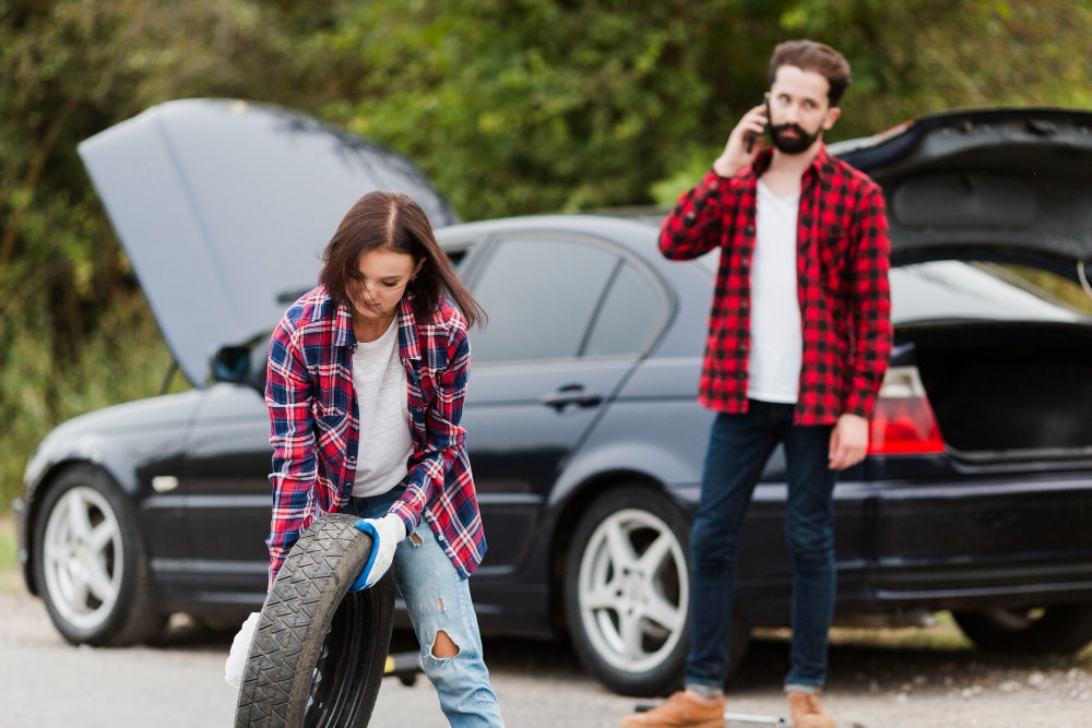 W razie problemów z samochodem w trasie, reaguj natychmiastowo. Źródło: https://www.freepik.com/free-photo/woman-holding-spare-tire-man-talking-phone_5381415.htm#fromView=search&amp;page=1&amp;position=40&amp;uuid=eaf3e3b0-ea83-4f18-bba7-eb12efe37417&amp;query=awaria+samochodu