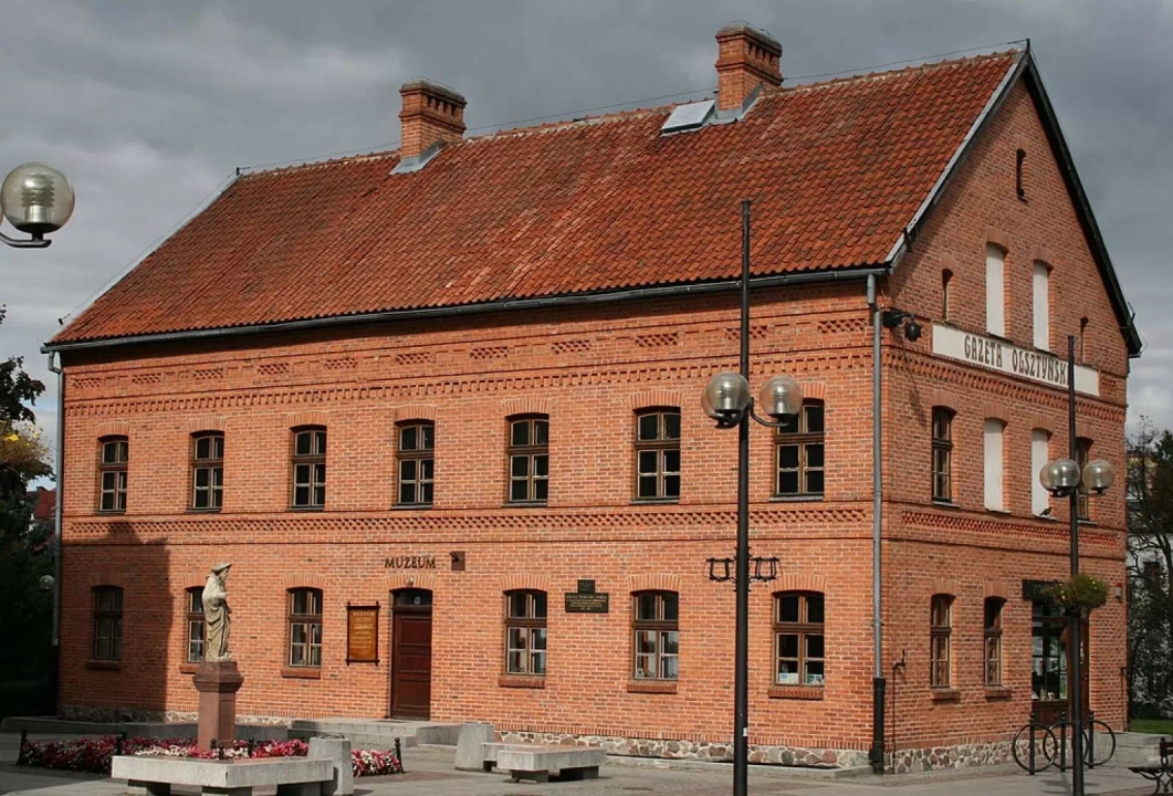 Muzeum z czerwonej cegły, przed którego budynkiem znajduje się rzeźba.