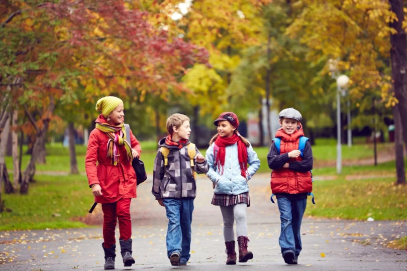Dzieci idące przez park jesienią